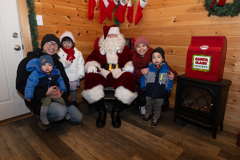 A smiling family taking a picture with santa claus